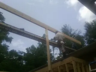 Carpenter setting a ridge beam over a new addition frame — Ice Dam Removal by Roofing Brothers in Philadelphia